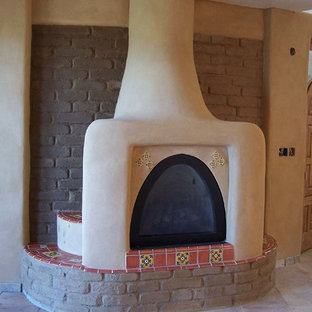 Großes, Offenes Mediterranes Wohnzimmer mit beiger Wandfarbe, Porzellan-Bodenfliesen, Hängekamin und verputztem Kaminsims in Albuquerque
