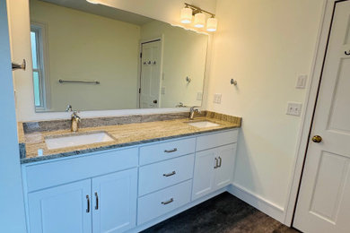 Inspiration for a large timeless master white tile and ceramic tile ceramic tile, black floor and double-sink bathroom remodel in Minneapolis with flat-panel cabinets, white cabinets, a one-piece toilet, beige walls, an undermount sink, granite countertops, beige countertops and a built-in vanity