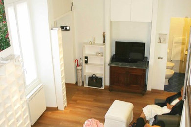 Idée de décoration pour un petit salon mansardé ou avec mezzanine design avec un sol en bois brun et un sol marron.