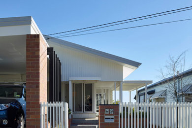 Design ideas for a mid-sized modern two-storey brick white house exterior in Brisbane with a gable roof, a metal roof, a white roof and clapboard siding.