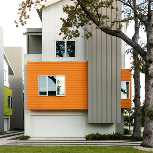 ヒューストンのコンテンポラリースタイルのおしゃれな三階建ての家 (混合材サイディング、オレンジの外壁) の写真