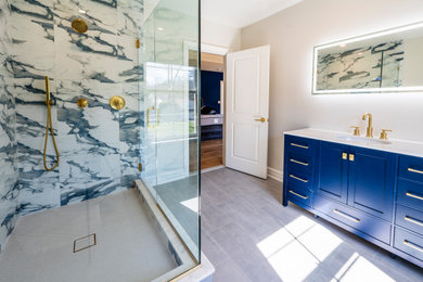 Example of a mid-sized 3/4 multicolored tile and porcelain tile light wood floor, white floor and single-sink corner shower design in New York with shaker cabinets, blue cabinets, a two-piece toilet, gray walls, an undermount sink, quartz countertops, a hinged shower door, white countertops, a niche and a freestanding vanity