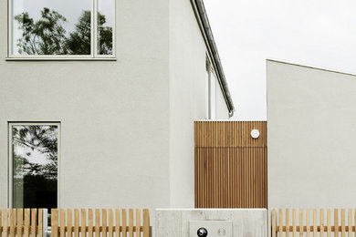 Mittelgroßes, Zweistöckiges Modernes Haus mit Mix-Fassade, grauer Fassadenfarbe und Satteldach in Berlin
