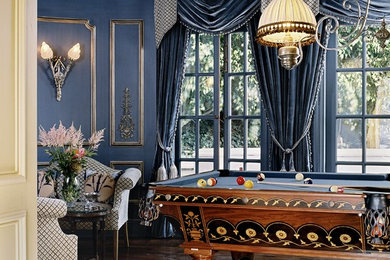 Elegant brown floor family room photo in Los Angeles with blue walls