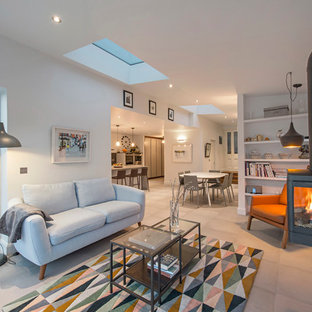 Modern inredning av ett stort allrum med öppen planlösning, med vita väggar, klinkergolv i keramik och en hängande öppen spis