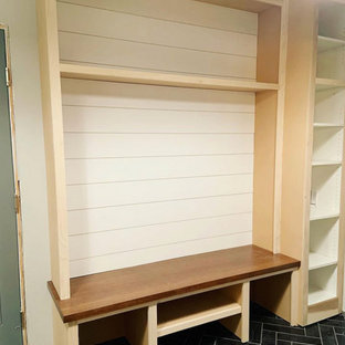 Idéer för en mellanstor klassisk bruna tvättstuga, med en allbänk, skåp i shakerstil, vita skåp, träbänkskiva, stänkskydd i skiffer, skiffergolv, en tvättmaskin och torktumlare bredvid varandra och svart golv