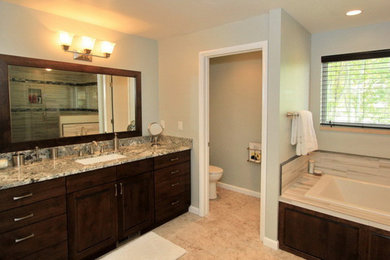 Inspiration for a mid-sized transitional master ceramic tile bathroom remodel in Salt Lake City with raised-panel cabinets, dark wood cabinets, granite countertops, an undermount sink and a one-piece toilet
