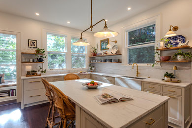 Transitional l-shaped dark wood floor and brown floor kitchen photo in Portland with an undermount sink, shaker cabinets, gray cabinets, white backsplash, stone slab backsplash, an island and white countertops