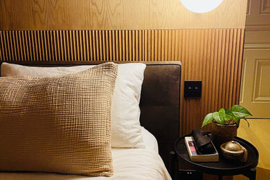 Foto de dormitorio principal minimalista con paredes rosas, suelo de madera clara, suelo beige y madera