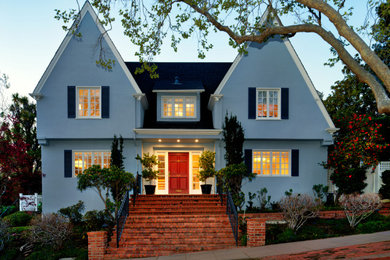 Immagine della villa grande blu contemporanea a due piani con rivestimento in stucco, tetto a capanna, copertura a scandole e tetto nero