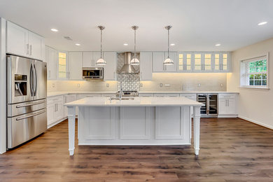 Eat-in kitchen - mid-sized contemporary l-shaped laminate floor and brown floor eat-in kitchen idea in DC Metro with an undermount sink, shaker cabinets, white cabinets, quartzite countertops, subway tile backsplash, an island, white countertops, white backsplash and stainless steel appliances