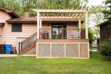 This is an example of a mid-sized traditional courtyard patio in Chicago with decking and a pergola.