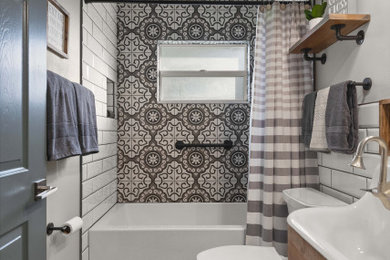 Inspiration for an industrial kids bathroom in Orlando with furniture-like cabinets, medium wood cabinets, an alcove tub, a two-piece toilet, white tile, subway tile, grey walls, cement tiles, a trough sink and grey floor.