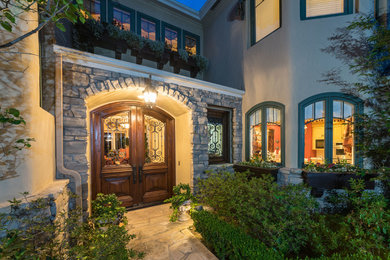 Large mediterranean beige two-story stucco exterior home idea in Other