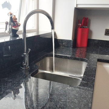 White handleless gloss, with Steel Grey worktops and red accessories