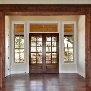 オースティンの両開きドアサンタフェスタイルのおしゃれな玄関 (ベージュの壁、濃色木目調のドア) の写真