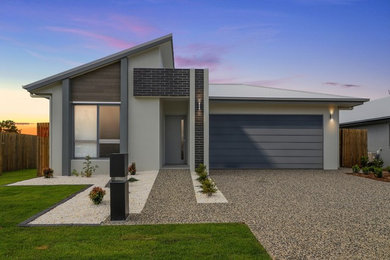 This is an example of a modern one-storey grey house exterior in Townsville with concrete fiberboard siding and a metal roof.
