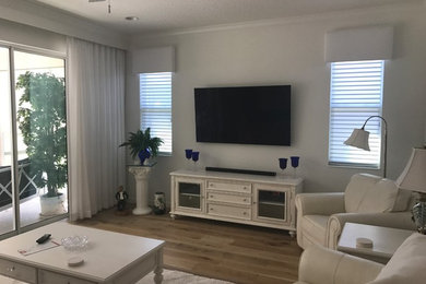 Imagen de salón clásico de tamaño medio con paredes blancas y televisor colgado en la pared
