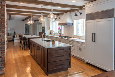 Large cottage galley light wood floor, brown floor and exposed beam kitchen pantry photo in Other with an undermount sink, flat-panel cabinets, white cabinets, quartz countertops, white backsplash, subway tile backsplash, paneled appliances, two islands and white countertops