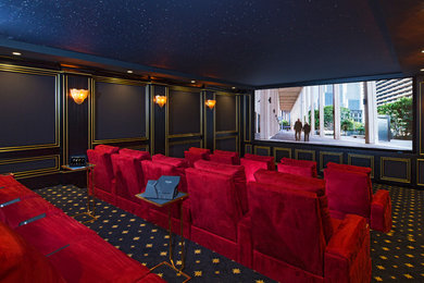 Photo of a large traditional enclosed home theatre in Los Angeles with carpet, a projector screen and black walls.
