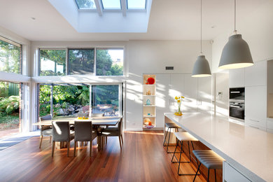This is an example of a contemporary kitchen/dining combo in Canberra - Queanbeyan with white walls and medium hardwood floors.