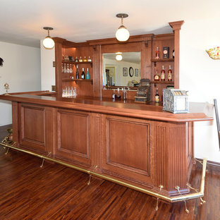 他の地域の中サイズのヴィクトリアン調のおしゃれなホームバー (家具調キャビネット、赤いキャビネット、木材カウンター、木材のキッチンパネル、濃色無垢フローリング、黄色い床、赤いキッチンカウンター) の写真