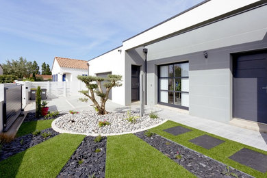 Photo of a mid-sized contemporary front yard full sun driveway for spring in Nantes with a garden path and gravel.