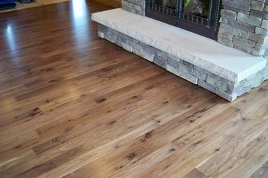 Inspiration for a medium tone wood floor and multicolored floor living room remodel in Detroit with a standard fireplace and a stone fireplace