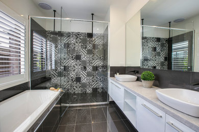 Inspiration for a large contemporary master bathroom in Melbourne with flat-panel cabinets, white cabinets, a drop-in tub, gray tile, white walls, a vessel sink, ceramic tile, engineered quartz benchtops, an alcove shower and grey benchtops.