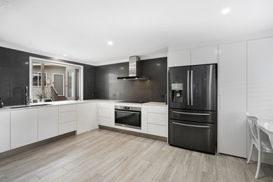 Design ideas for a kitchen pantry in Gold Coast - Tweed with an undermount sink, flat-panel cabinets, white cabinets, quartz benchtops, black splashback, ceramic splashback, stainless steel appliances, no island and white benchtop.
