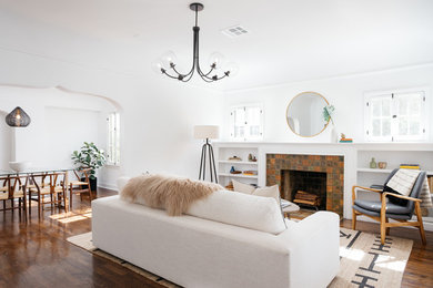 Trendy medium tone wood floor and brown floor living room photo in Los Angeles with white walls, a standard fireplace and a tile fireplace