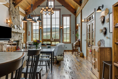 Living room - mid-sized rustic open concept dark wood floor and brown floor living room idea in Denver with gray walls, a standard fireplace, a stone fireplace and a tv stand