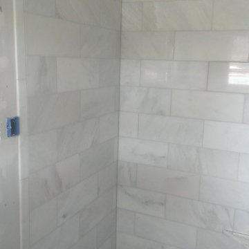BATHROOM - Calcutta Gold Marble Shower / Gray Penny Tile Floor