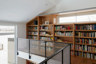 Expansive modern home office in Ottawa with a library, white walls, concrete floors, no fireplace, a built-in desk and grey floor.