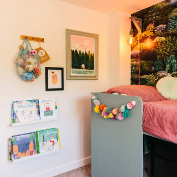 An eclectic children's bedroom with pops of pink and nature inspired wallpaper