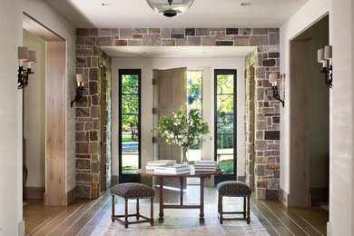 Example of a mid-sized mountain style dark wood floor and brown floor entryway design in Denver with beige walls and a medium wood front door