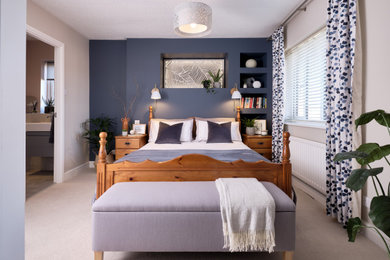 This is an example of a mid-sized modern master bedroom in Gloucestershire with blue walls, carpet, no fireplace and beige floor.