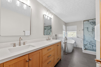 Large master multicolored tile and porcelain tile porcelain tile, gray floor and double-sink bathroom photo in Columbus with shaker cabinets, light wood cabinets, a two-piece toilet, gray walls, an undermount sink, quartz countertops, a hinged shower door, white countertops, a niche and a freestanding vanity