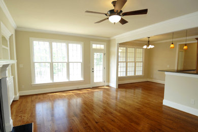 Inspiration for a mid-sized timeless formal and open concept medium tone wood floor living room remodel in Denver with beige walls, a standard fireplace, a wood fireplace surround and a media wall