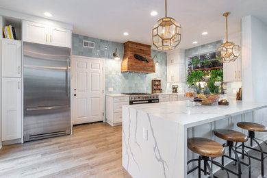 Inspiration for a large country u-shaped kitchen in Orange County with a farmhouse sink, recessed-panel cabinets, white cabinets, quartz benchtops, blue splashback, ceramic splashback, stainless steel appliances, laminate floors, multi-coloured floor and white benchtop.