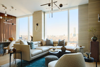 Example of a large trendy open concept light wood floor, beige floor and wallpaper living room design in Boston with beige walls, a standard fireplace, a stone fireplace and no tv