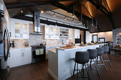 Foto på ett stort rustikt vit kök, med en undermonterad diskho, skåp i shakerstil, vita skåp, bänkskiva i kvartsit, grått stänkskydd, stänkskydd i kalk, rostfria vitvaror, mellanmörkt trägolv, en köksö och brunt golv