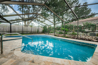 Large beach style backyard brick and custom-shaped natural pool photo in Tampa