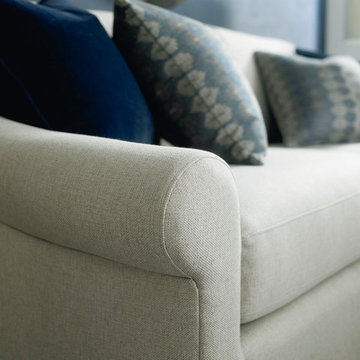 Aeron features a sloped rolled arm, top stitched boxed loose back pillows and tw