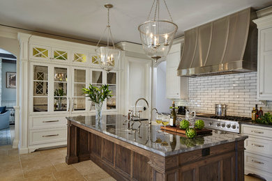 Elegant kitchen photo in Chicago with recessed-panel cabinets, white cabinets, white backsplash, subway tile backsplash, stainless steel appliances and an island