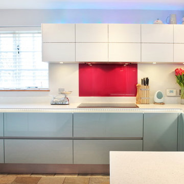 High gloss blue & matt white kitchen with red splash back