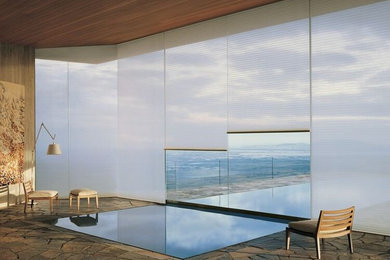 Design ideas for a mid-sized contemporary indoor rectangular pool in Miami with natural stone pavers.