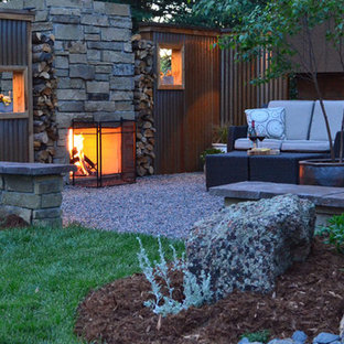 Cette photo montre un petit xéropaysage arrière tendance avec une exposition ensoleillée, du gravier et une cheminée.