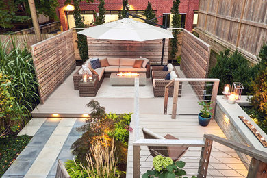 Mid-sized trendy backyard patio photo in Toronto with a fireplace, decking and an awning