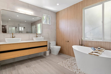 Example of a gray tile and porcelain tile porcelain tile, beige floor and double-sink freestanding bathtub design in Los Angeles with flat-panel cabinets, brown cabinets, gray walls, quartz countertops, white countertops and a floating vanity